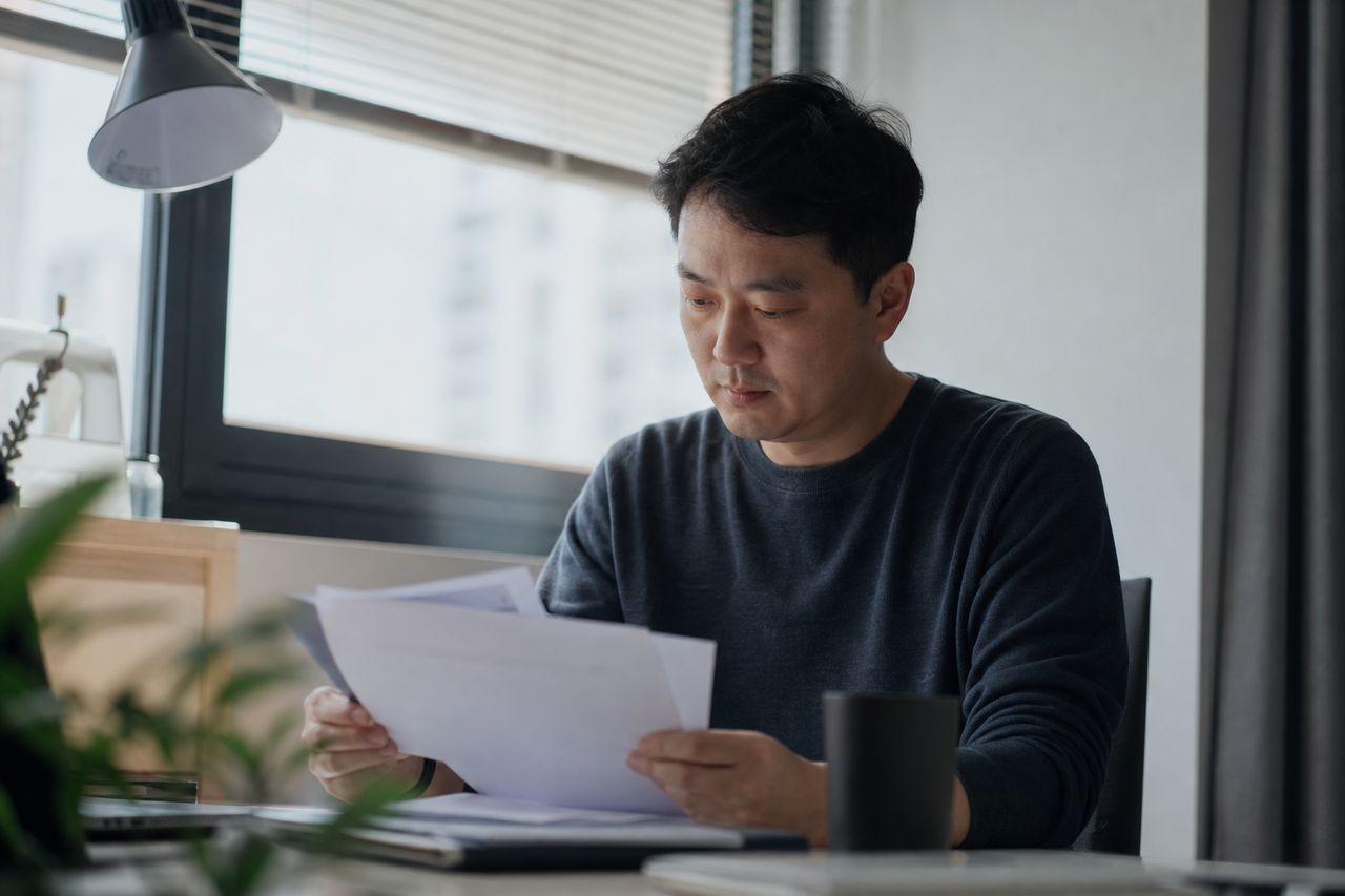 민간임대 안심확약서를 받았는데 사업이 멈췄을 때 — 얼마나 돌려받나·드나(금액·비용) 관련 상황을 보여주는 이미지 — 서류를 검토하는 모습